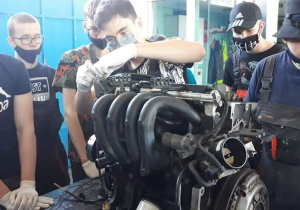 mechanicy z silnikiem samochodowym