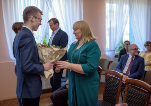 Abiturienci wręczający kwiaty dyrekcji szkoły