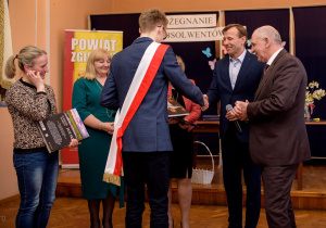 Marcel w obecności mamy odbiera z rąk Starosty zgierskiego i Dyrekcji szkoły nagrodę za wzorowe wyniki w nauce