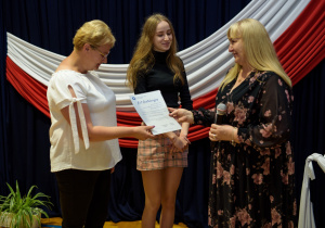 Pani dyrektor wręcza list gratulacyjny mamie Julii