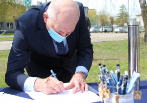 Starosta zgierski – Bogdan Jarota podpisuje dokument który zostanie umieszczony w kapsule czasu