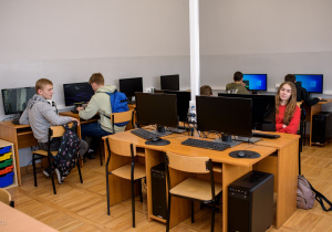 Uczniowie klasy przygotowawczej pracujący przy stanowiskach komputerowych w pracowni informatycznej