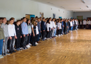 Młodzież zgromadzona na górnym korytarzu naszej szkoły podczas śpiewania hymnu