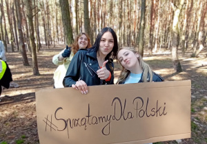 Wiktoria i Maja z tablicą z napisem #SprzątamyDlaPolski