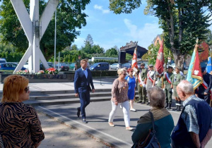 Złożenia kwiatów przez grupę osób przy pomniku