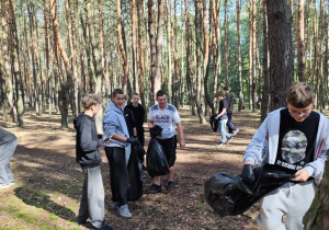 Uczniowie w lesie podczas sprzątania