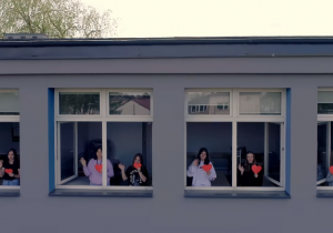 Kadr z filmu promocyjnego wykonanego przy pomocy szkolnego drona. Uczennice w oknach pracowni 1A i 1B.